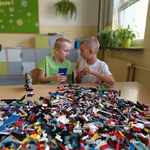 uczniowie siedzący przy stoliku_  podczas zajęć konstrukcyjnych z klocków Lego.jpg